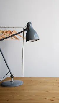Grey articulated desk lamp on a wooden surface